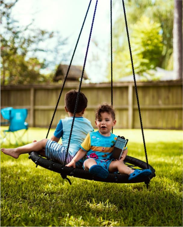 Zwei Kinder schwingen auf einer Nestschaukel